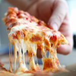 brazo-masculino-tomando-rebanada-pizza-fresca-sabrosa-queso_151013-13702